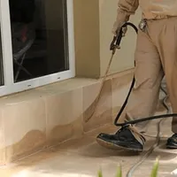 General pest control technician spraying exterior perimeter around a home in Chula Vista, CA